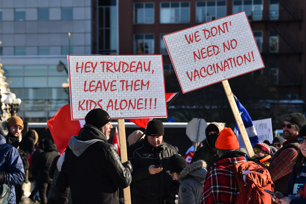 OTTAWA, ON - FEBRUARY 05: Protesters hold up posters condemning the vaccine mandates introduced by ...