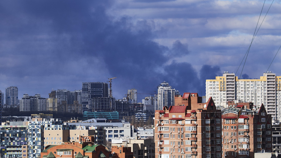 Smoke is seen rising from behind buildings following bombings on Feb. 27, 2022, in Kyiv, Ukraine. E...