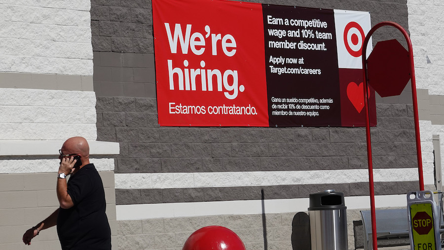 FILE: A 'We're hiring' sign hangs on the wall of a Target store on Dec. 3, 2021, in Miami, Florida....