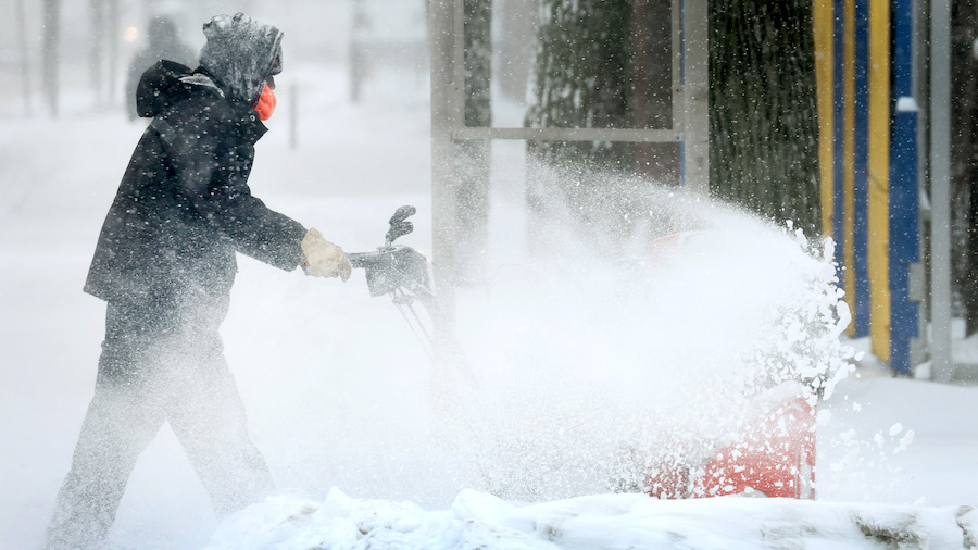 A person clears snow near a school on Feb. 2, 2022, in Chicago, Illinois. A massive storm, working ...