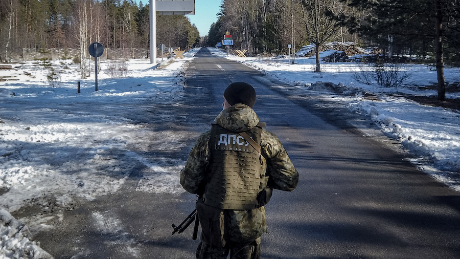 A member of the Ukrainian State Border Guard stands watch at the border crossing between Ukraine an...