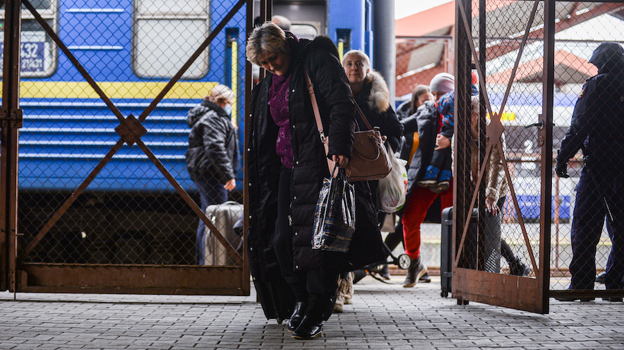 A woman carries a suitcase as she exits a train arriving from Odessa at Przemysl main train station...