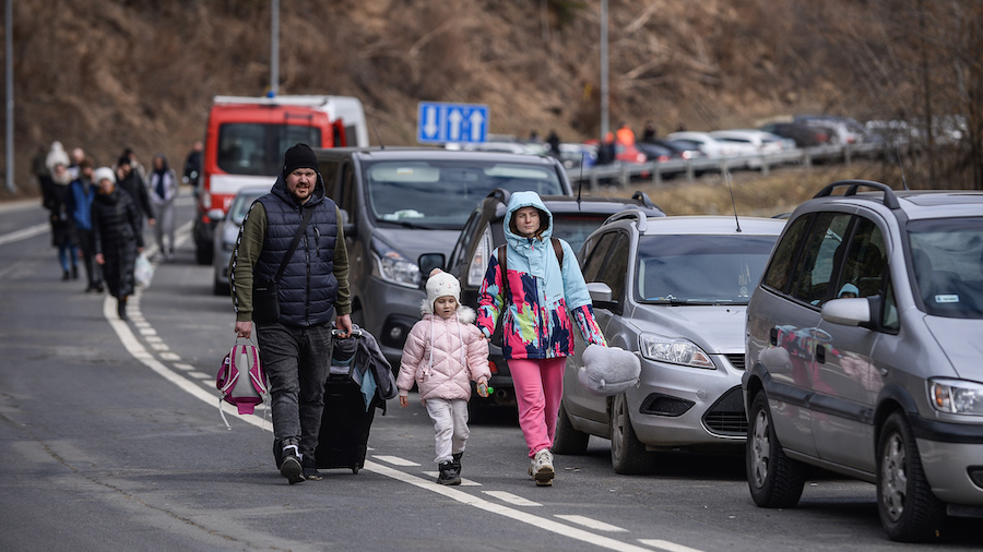 People carry their suitcases as they arrive in Poland after crossing a border check point on Februa...