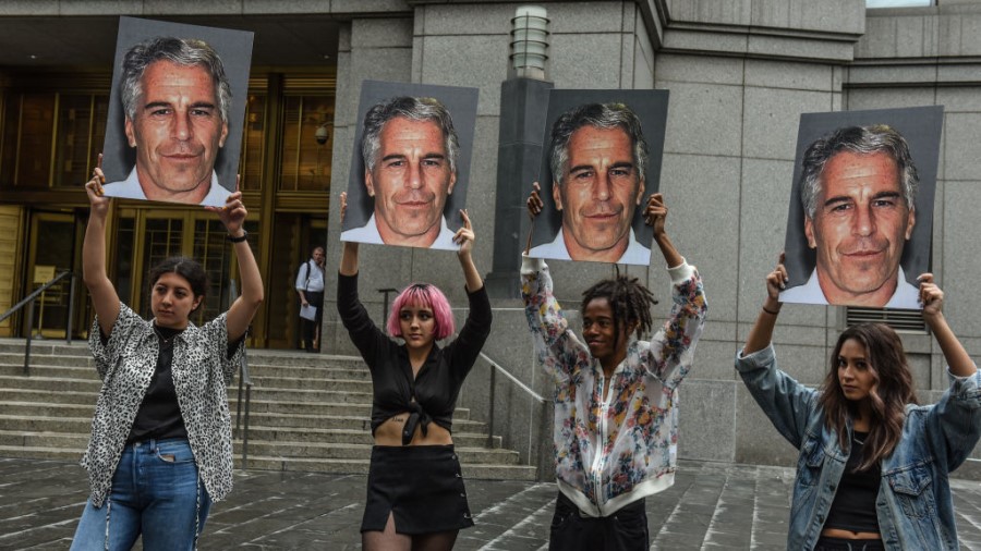 NEW YORK, NY - JULY 08 2019: A protest group called "Hot Mess" hold up signs of Jeffrey Epstein in ...