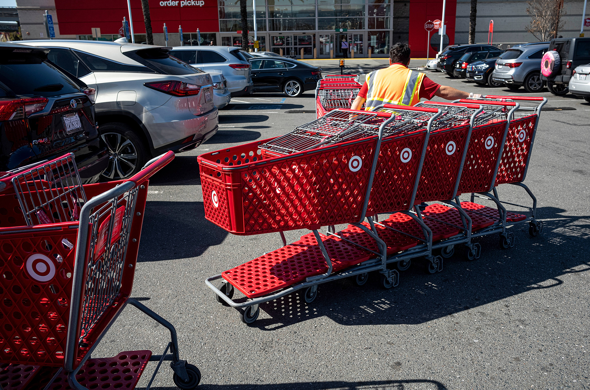 A worker collects shopping carts from the parking lot of a Target Corp. store in Emeryville, Califo...