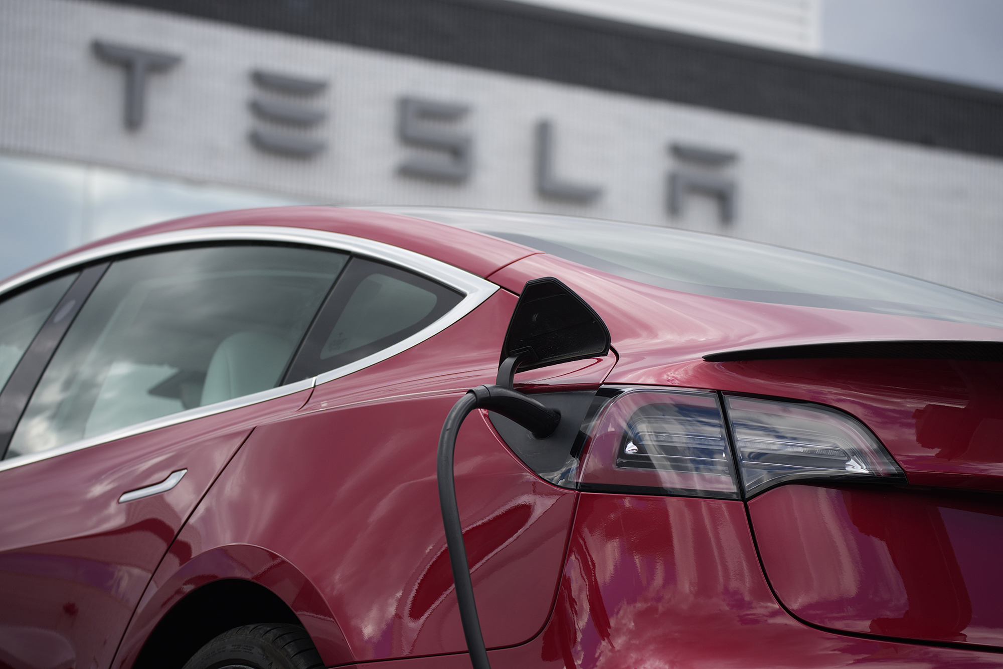 FILE - A 2021 Model 3 sedan charges at a Tesla dealership in Littleton, Colo., on June 27, 2021. On...