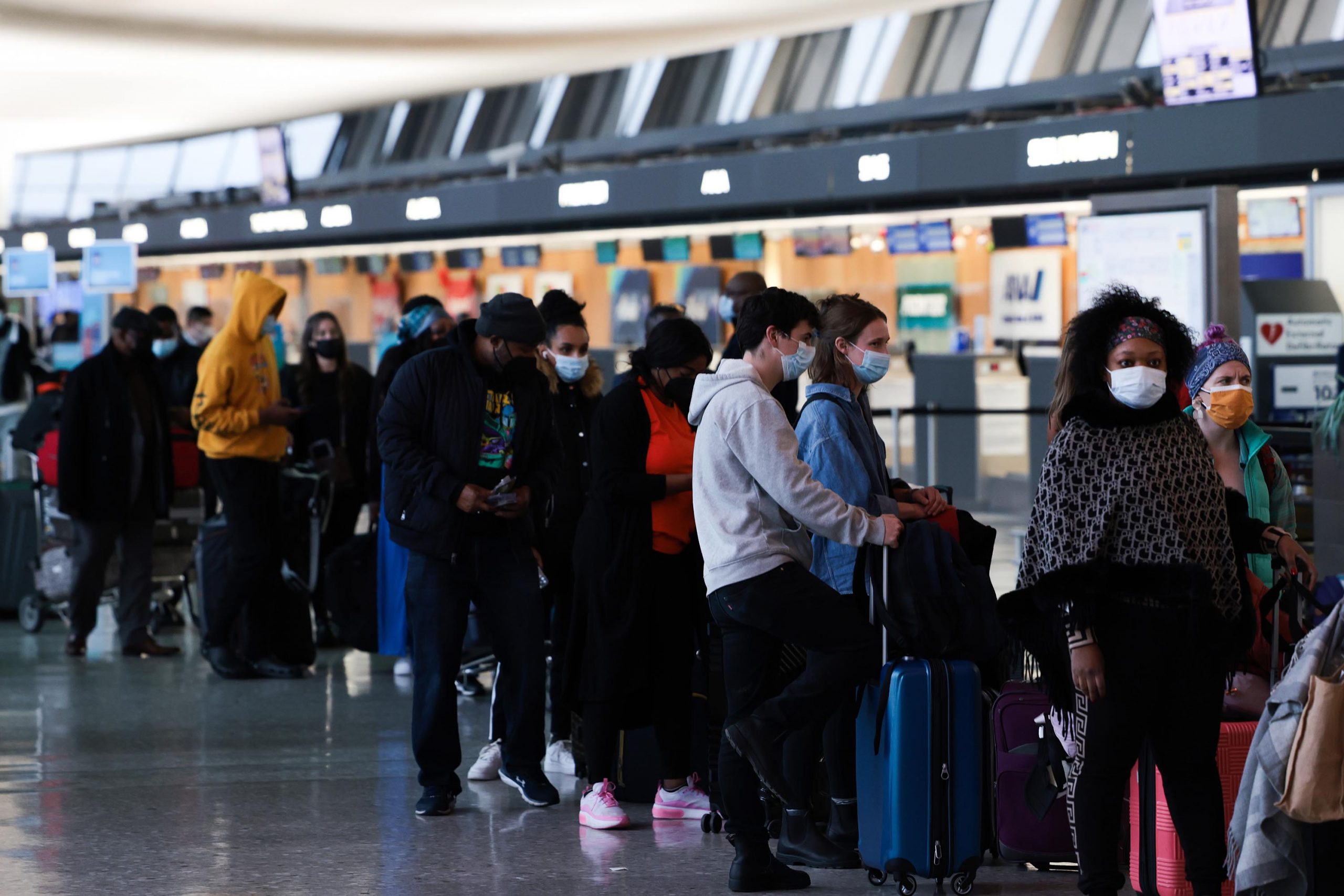 DULLES, VIRGINIA - DECEMBER 27: Passengers wait in line to check in for their flights at the Dulles...