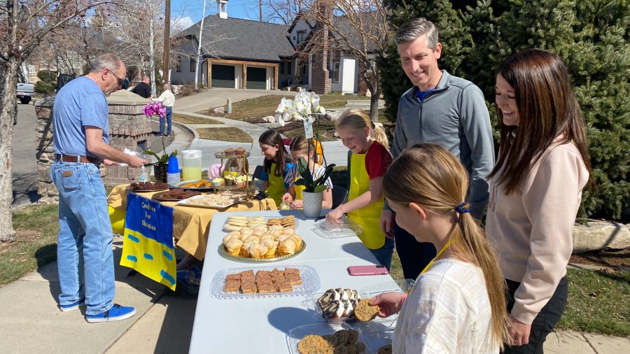 Brian and Amanda Grow help their children with a bake sale Friday to raise money for humanitarian a...