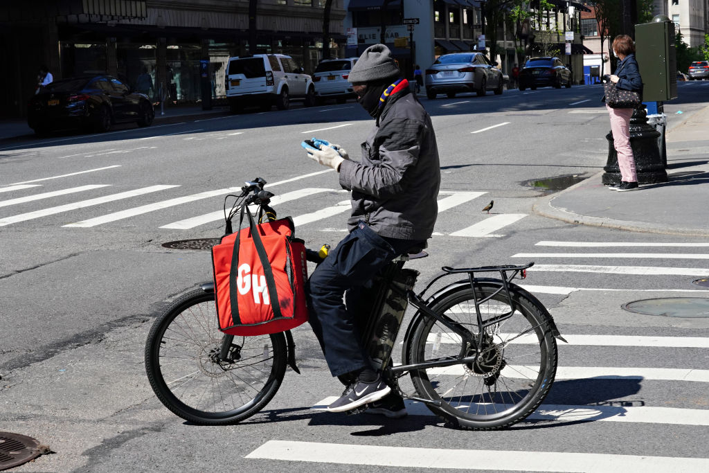 NEW YORK, NY - MAY 03: A Grubhub delivery person checks his phone during the coronavirus pandemic o...
