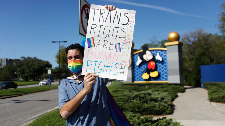 Disney employee Nicholas Maldonado holds a sign while protesting outside of Walt Disney World on Ma...