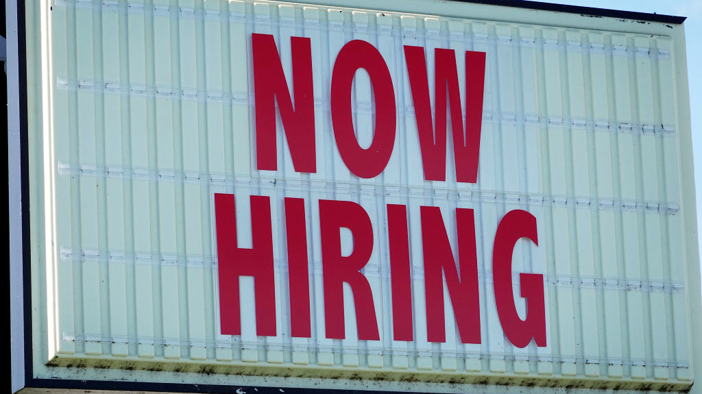 MIAMI, FLORIDA - DECEMBER 03:  A Now Hiring sign hangs in front of a Winn-Dixie grocery store on De...