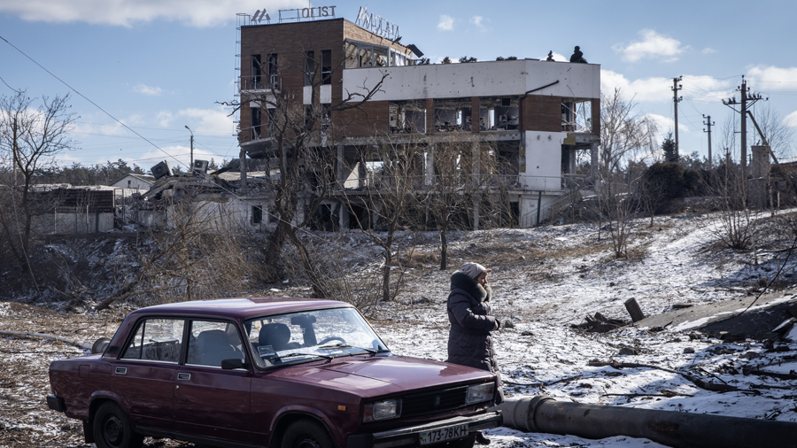 IRPIN, UKRAINE - MARCH 10: A woman waits to evacuate via a destroyed bridge in Irpin on March 10, 2...