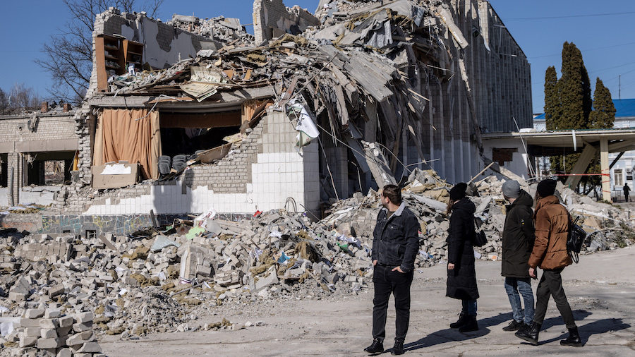 People look at damage at a school that was hit by a Russian attack 10 days ago on March 20, 2022 in...