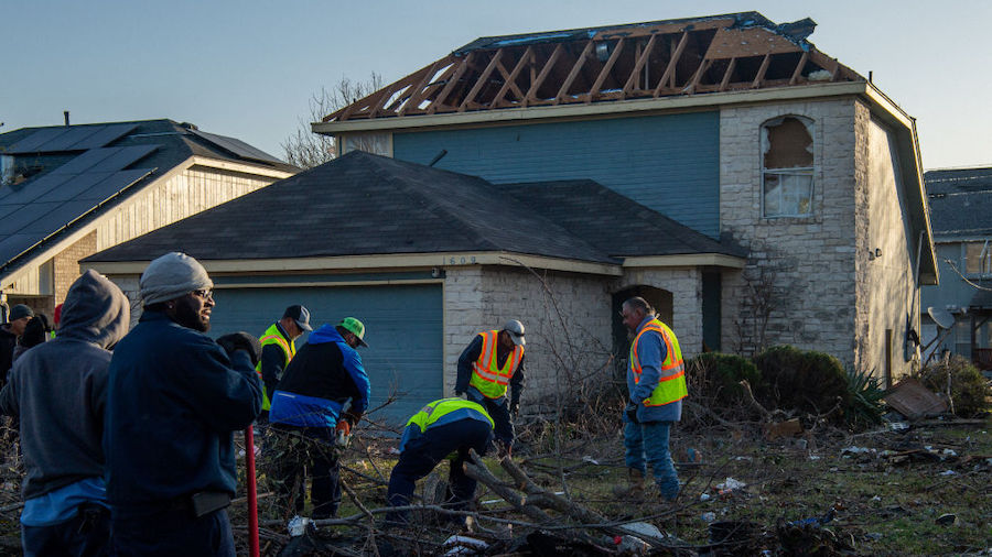 A construction crew works to clean up debris in a tornado damaged neighborhood on March 22, 2022 in...