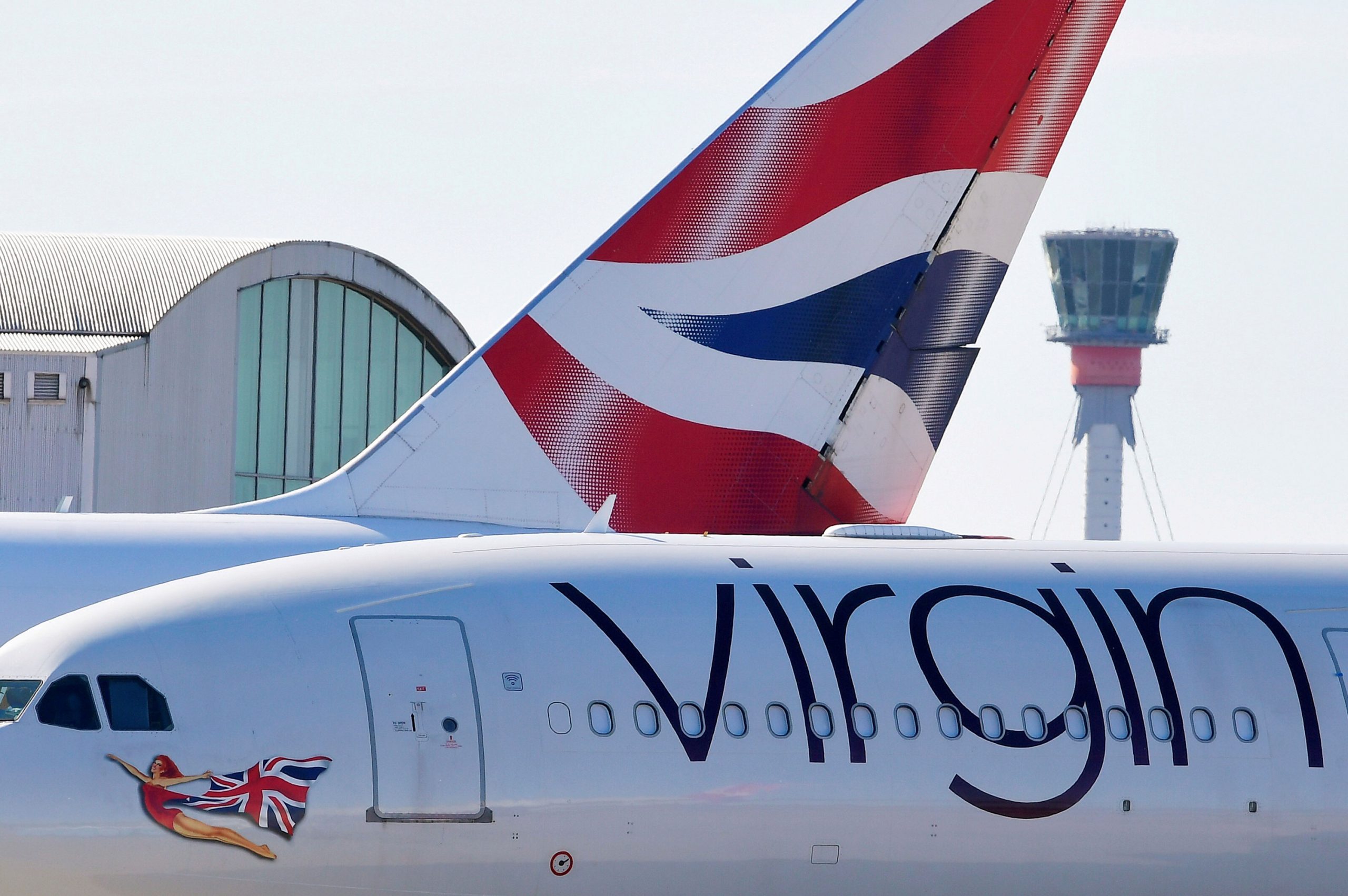 FILE PHOTO: A British airways aeroplane tailfin and a Virgin Atlantic areoplane are seen with the c...