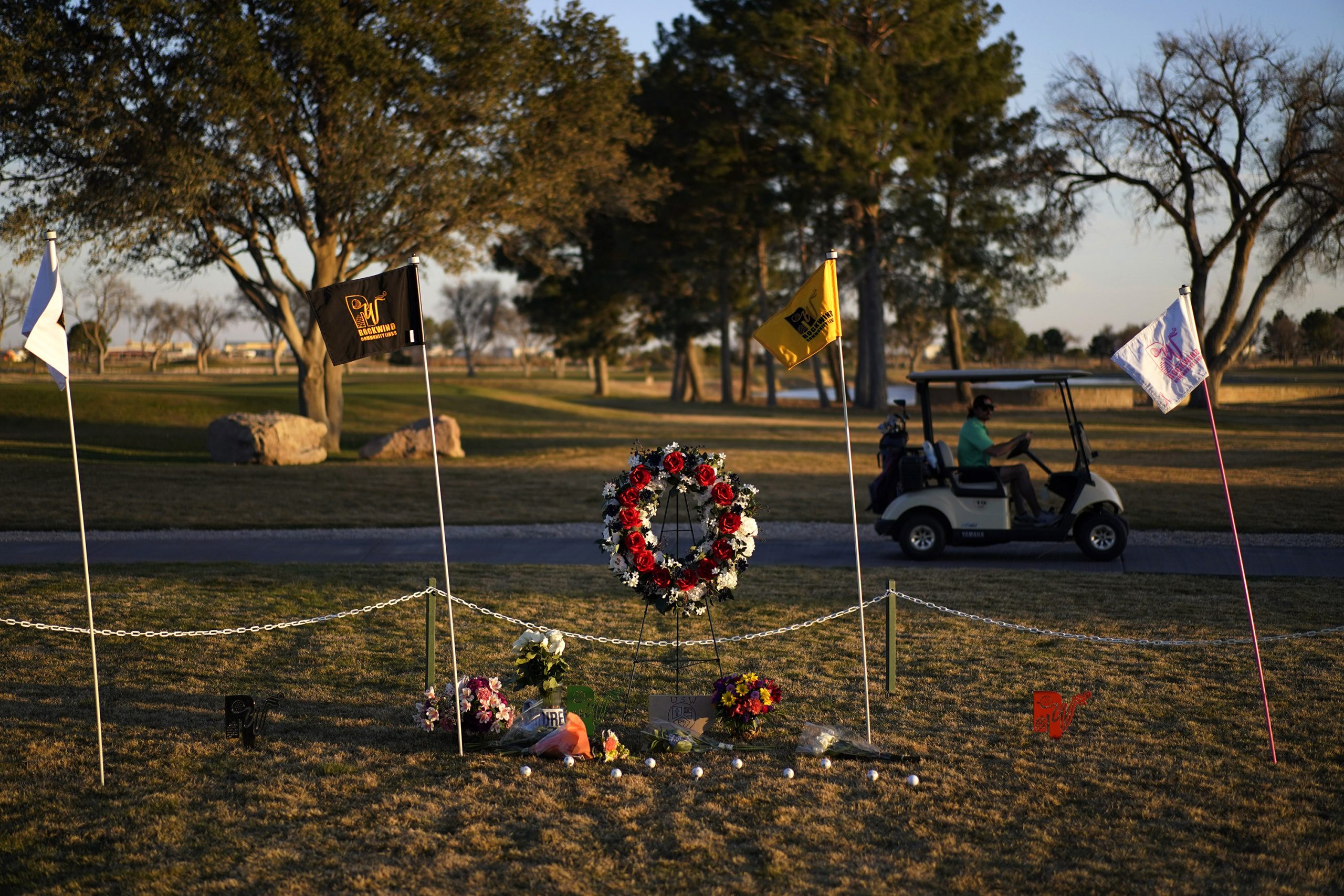 A golfer drives by a makeshift memorial at the Rockwind Community Links, Wednesday, March 16, 2022,...