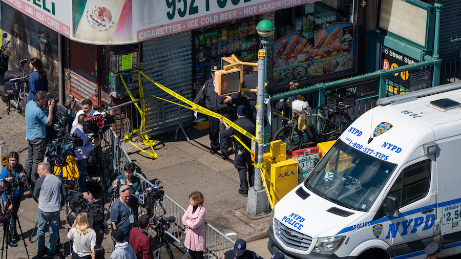 Members of the NYPD gather at the site of a shooting at the 36 St subway station on April 12, 2022 ...