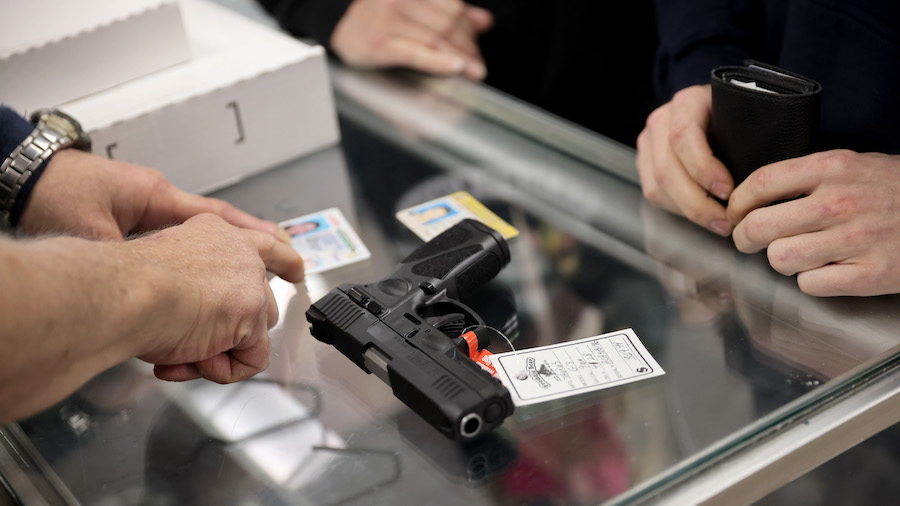 FILE: A customer purchases a gun at Freddie Bear Sports on April 8, 2021, in Tinley Park, Illinois....