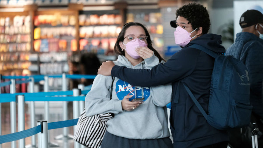 Travelers wearing masks walk around inside John F.  Kennedy Airport on April 19, 2022 in New York C...