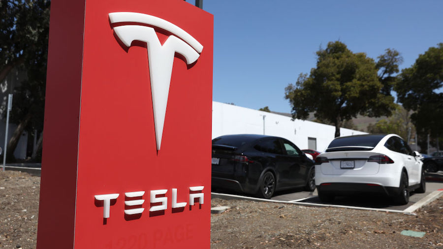 A sign is posted in front of a Tesla service center on April 20, 2022 in Fremont, California. Tesla...