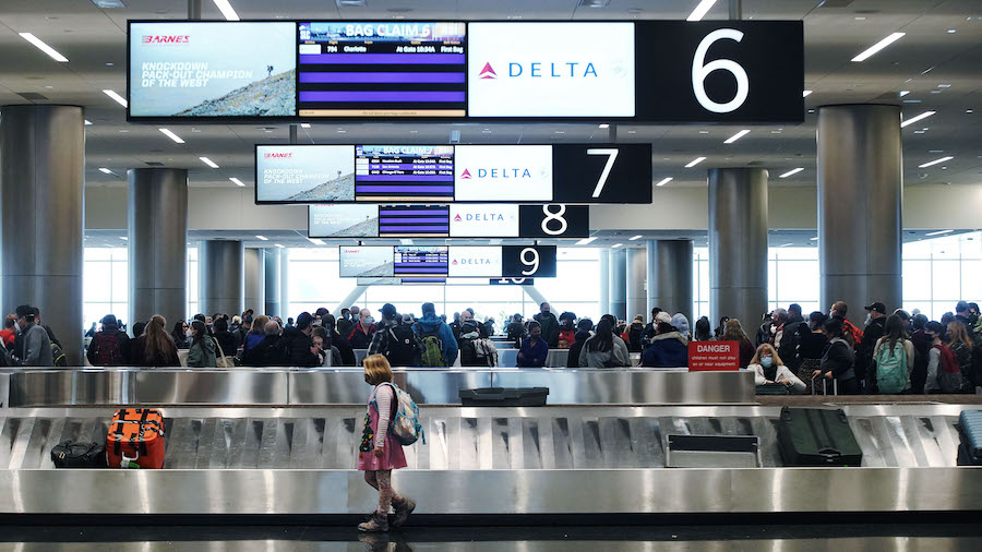 FILE - Travelers wait for baggage at Salt Lake City International Airport in Salt Lake City on Wedn...