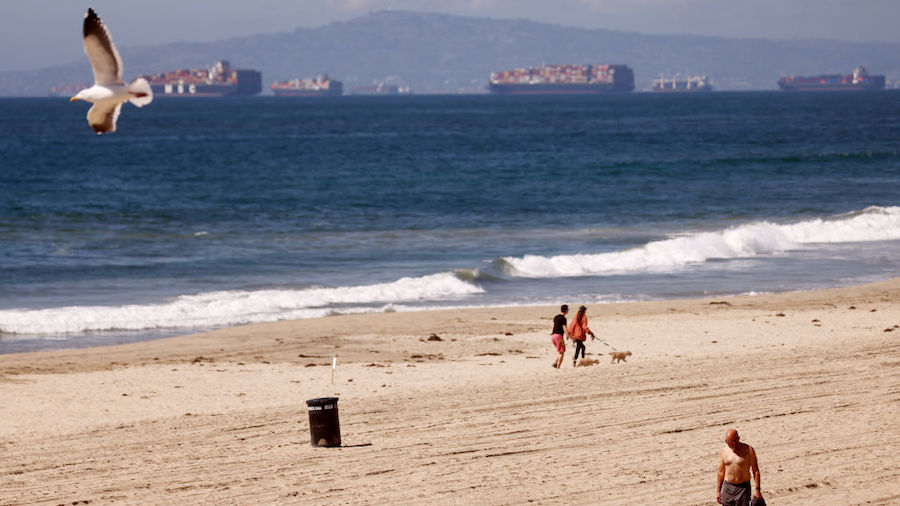 People walk on a mostly empty Huntington Beach about one week after an oil spill from an offshore o...