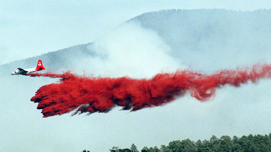 405746 01: A tanker drops slurry on a wildfire in the Santa Fe National Forest May 22, 2002 near Co...