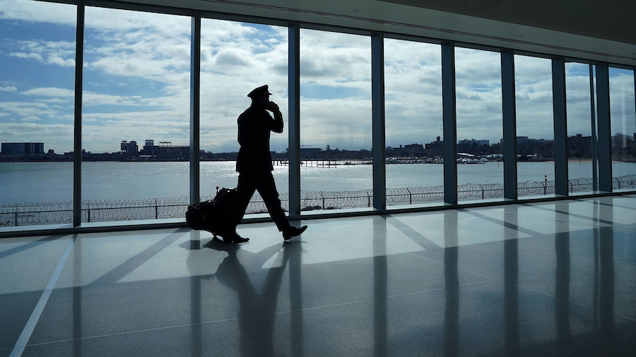 A pilot walks past the windows at the newly renovated Delta terminal D at LaGuardia Airport in New ...