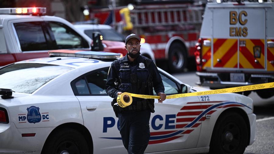 A police officer secures the area after a shooting Friday in northwest Washington, D.C. (Brendan Sm...
