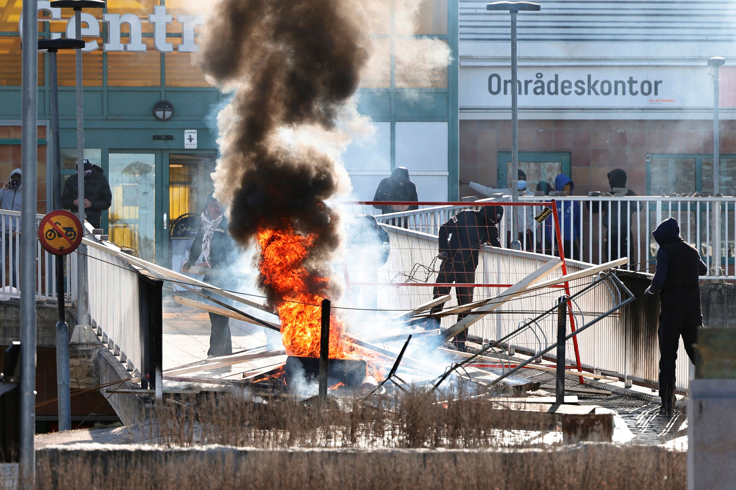 Protesters burn a barricade at the entrance to a shopping center during rioting in Norrkoping, Swed...