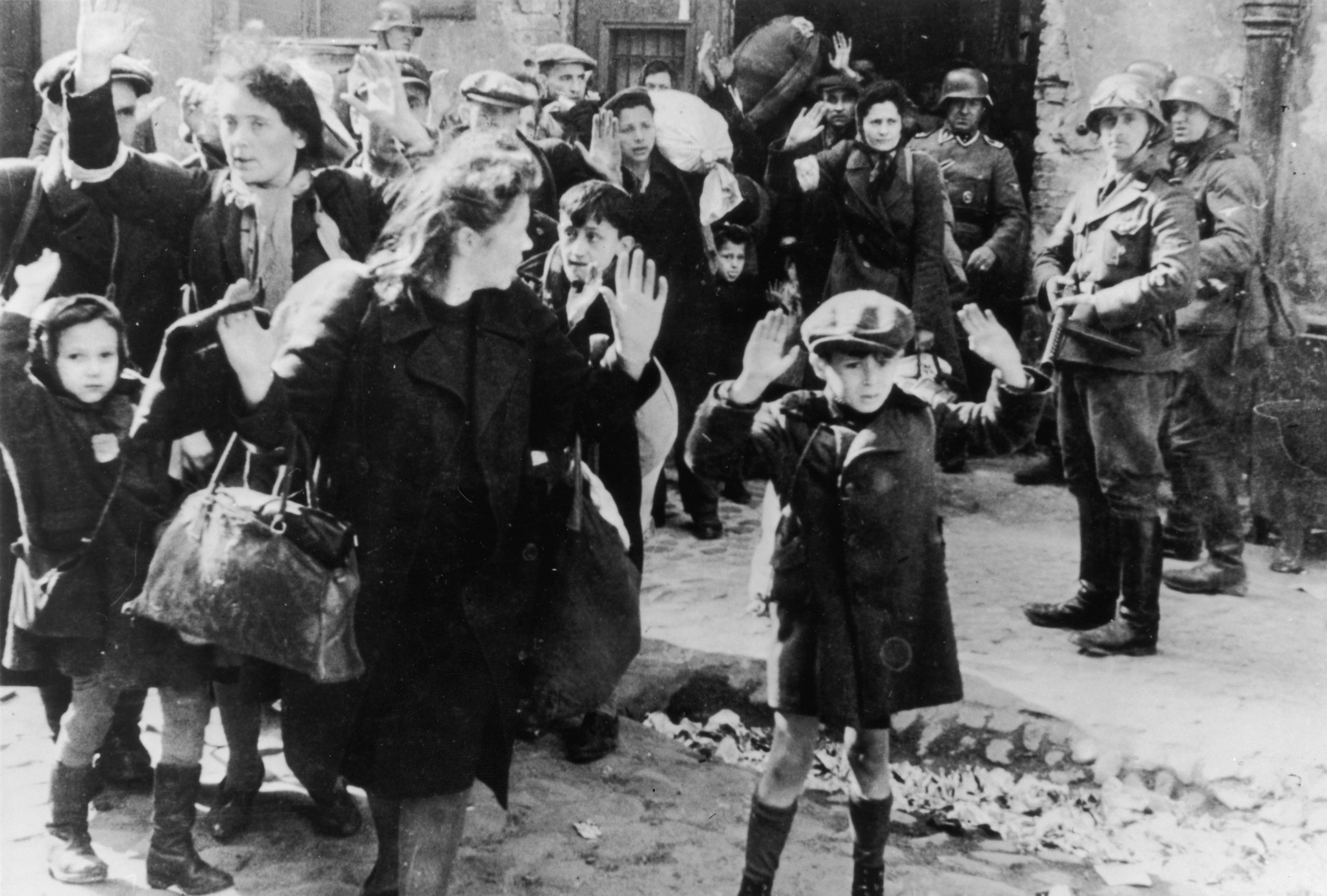 A group of Jewish civilians being held at gunpoint by German SS troops after being forced out of a ...
