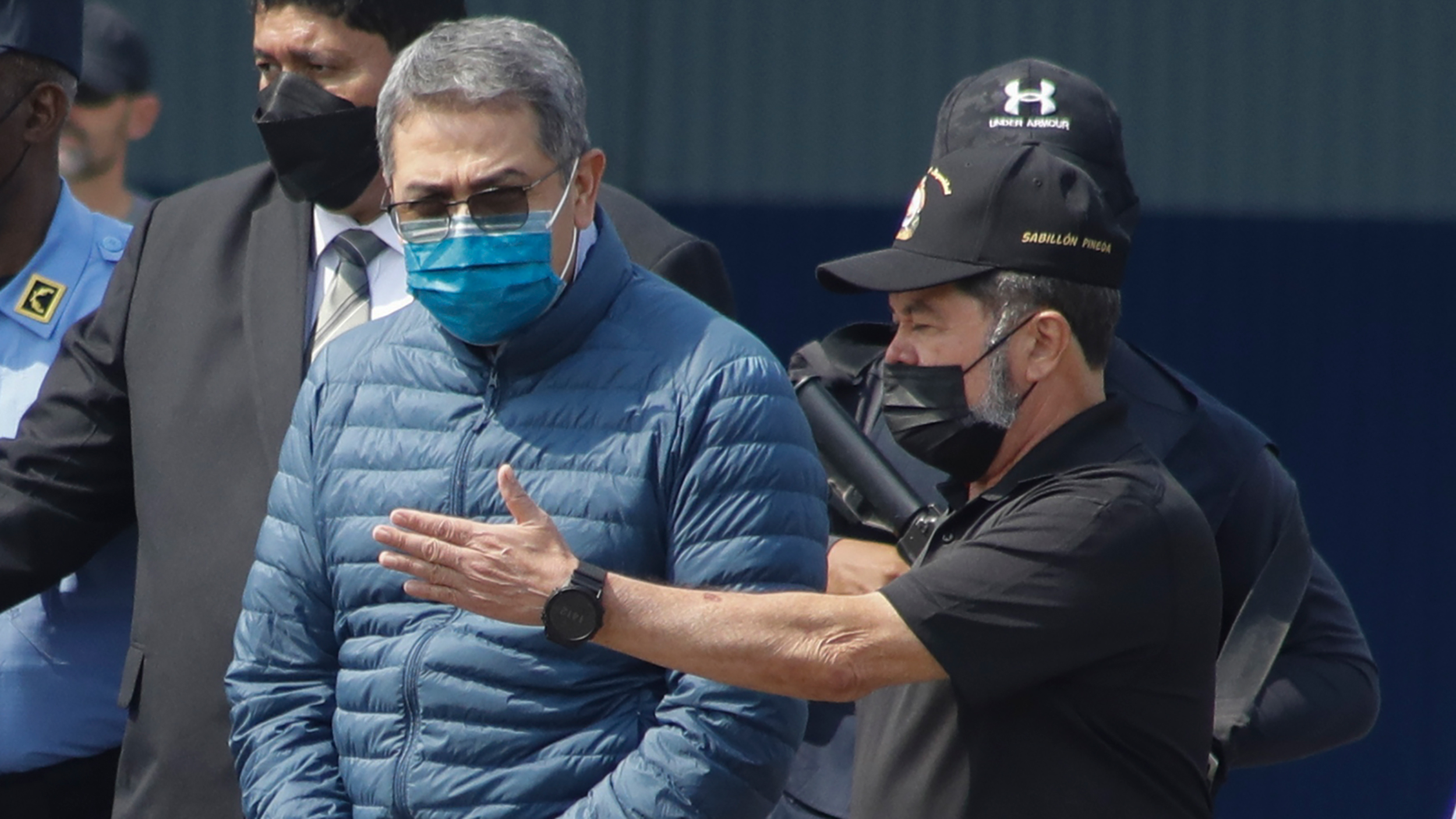 Former Honduran President Juan Orlando Hernandez, center, is taken in handcuffs to a waiting aircra...