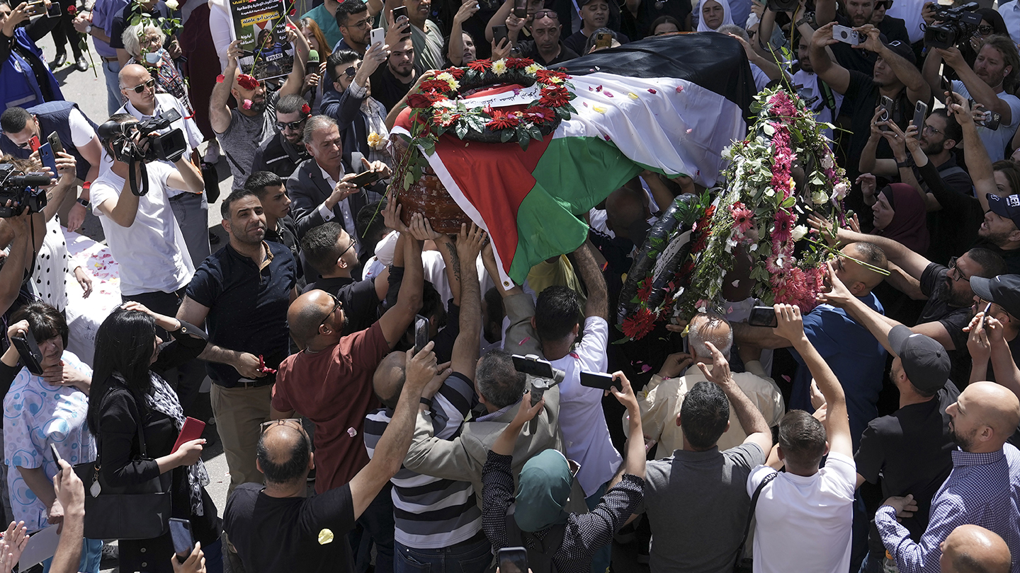 Family, friends and colleagues of slain Al Jazeera journalist Shireen Abu Akleh carry her coffin to...