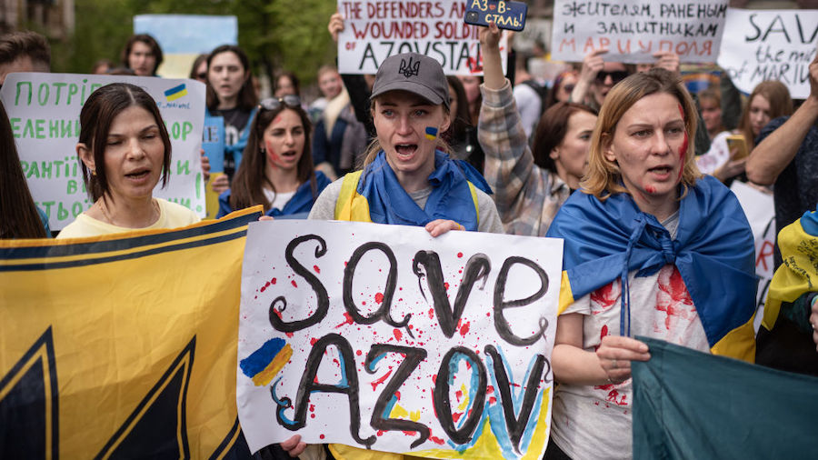 People hold banners and shout slogans during a demonstration in support of Mariupol defenders on Ma...