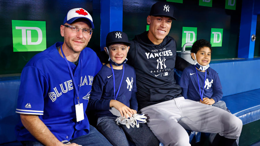 Aaron Judge #99 of the New York Yankees meets with Toronto Blue Jays fan Mike Lanzillotta (L) and Y...