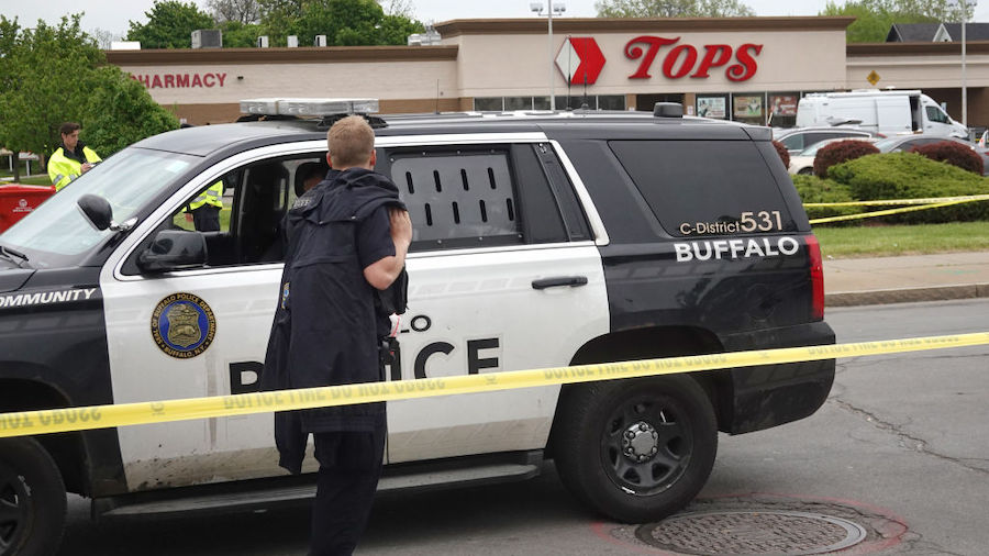 Police and FBI agents continue their investigation of the shooting at Tops Market on May 16, 2022 i...