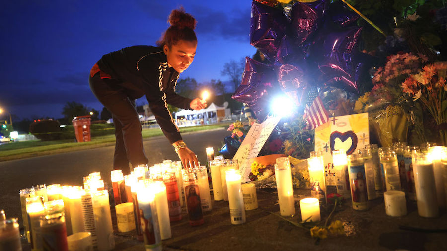 Mourners light candles at a makeshift memorial outside of Tops market on May 16, 2022 in Buffalo, N...