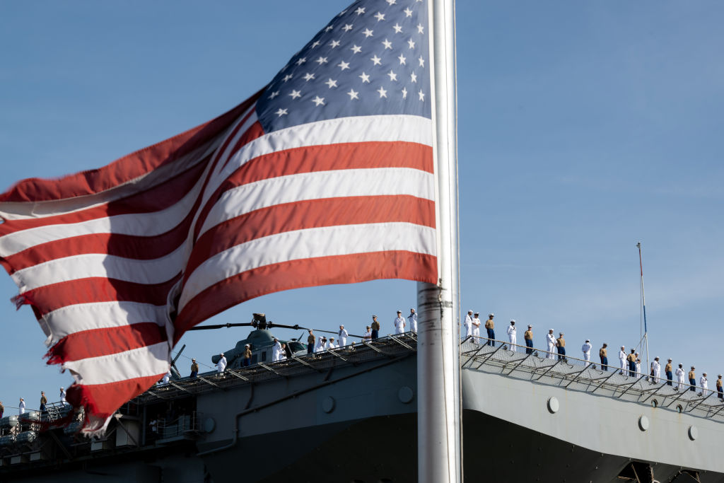 FILE: NEW YORK, NEW YORK - MAY 25: An American flag framMarines and Navy sailors from the USS Bataa...