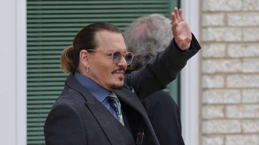 Actor Johnny Depp waves to a fan during a break in his trial at the Fairfax County Courthouse on Ma...