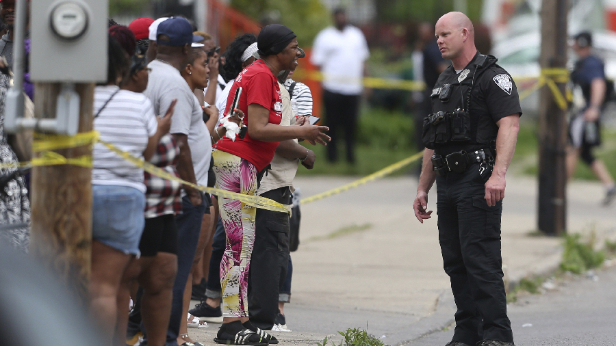 Police speak to bystanders after the shooting at a supermarket on May 14, in Buffalo, New York. (Cr...