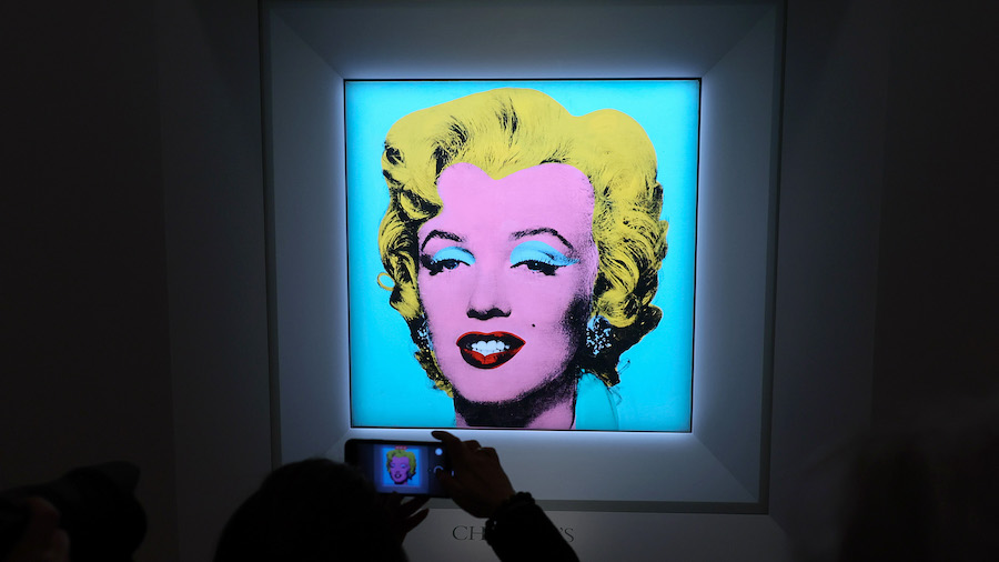 A guest takes a photo during Christie's announcement that it will offer Andy Warhol's "Shot Sage Bl...