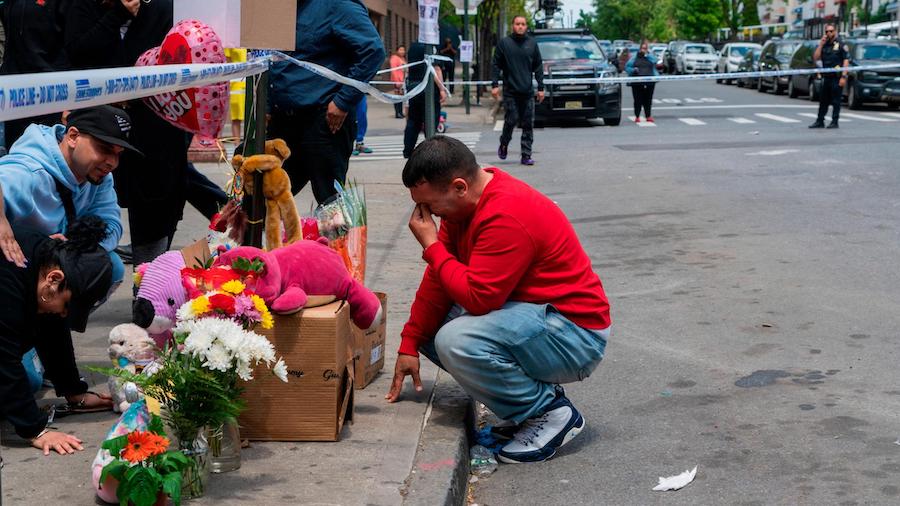 Family, friends and neighbors pay their respects at a makeshift memorial in the Bronx on May 17 for...