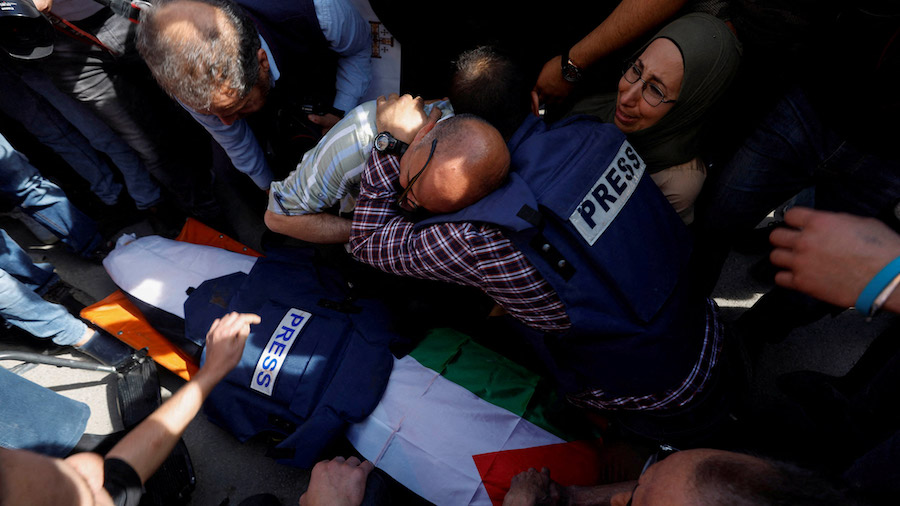Mourners, including journalists, react next to the body of Al Jazeera reporter Shireen Abu Akleh. (...