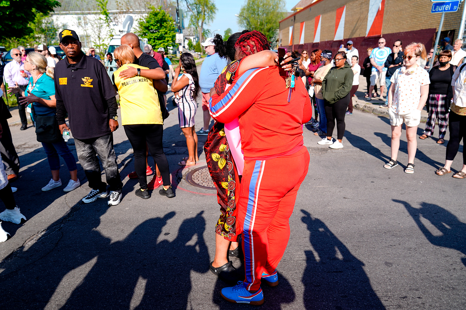 People embrace outside the scene of a shooting at a supermarket, in Buffalo, N.Y., Sunday, May 15, ...