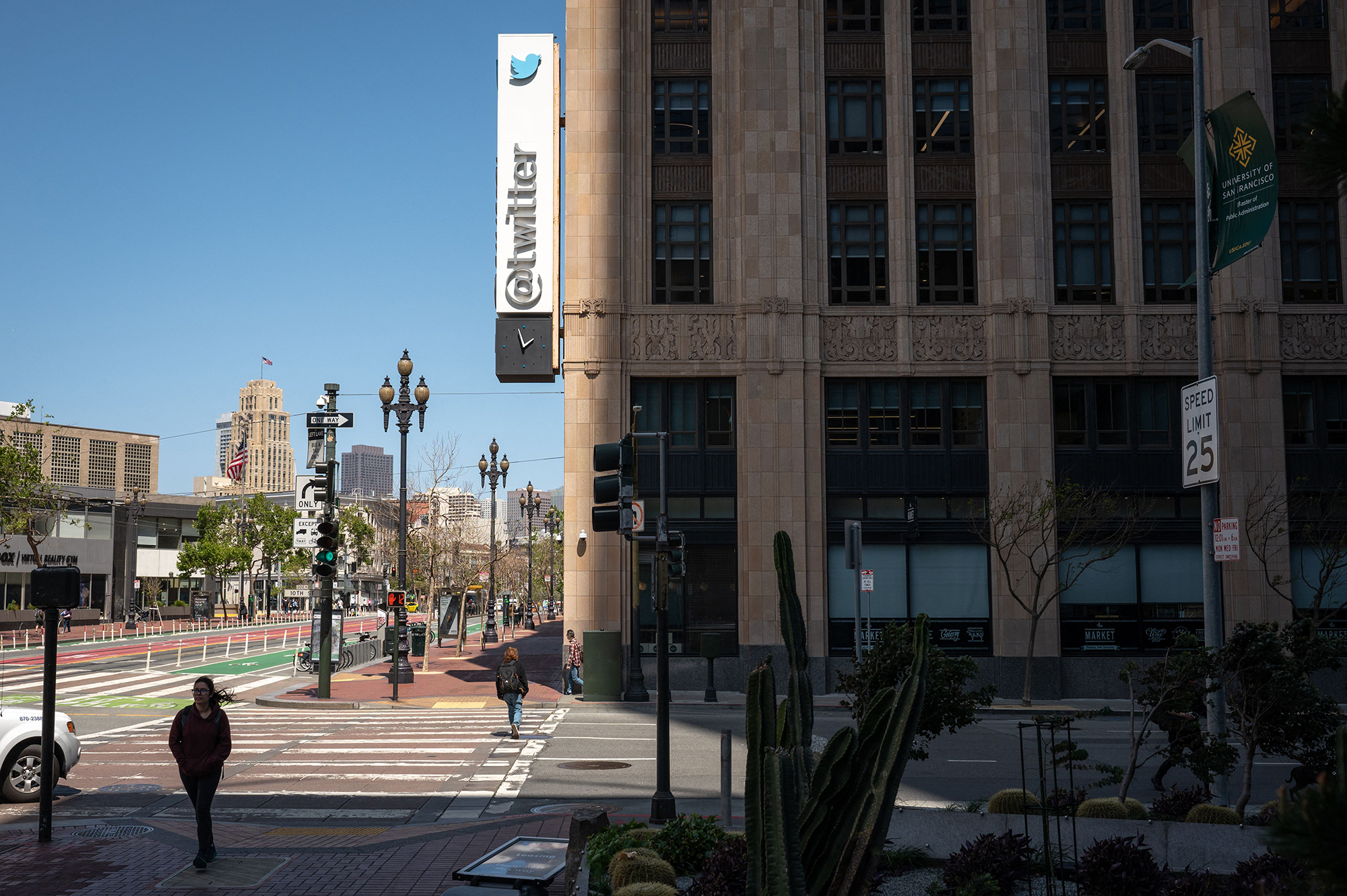 People walk past the Twitter headquarters on April 26, 2022 in downtown San Francisco, California. ...