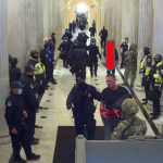 A Capitol Police officer tries to steer Peart out of the Capitol. (FBI)