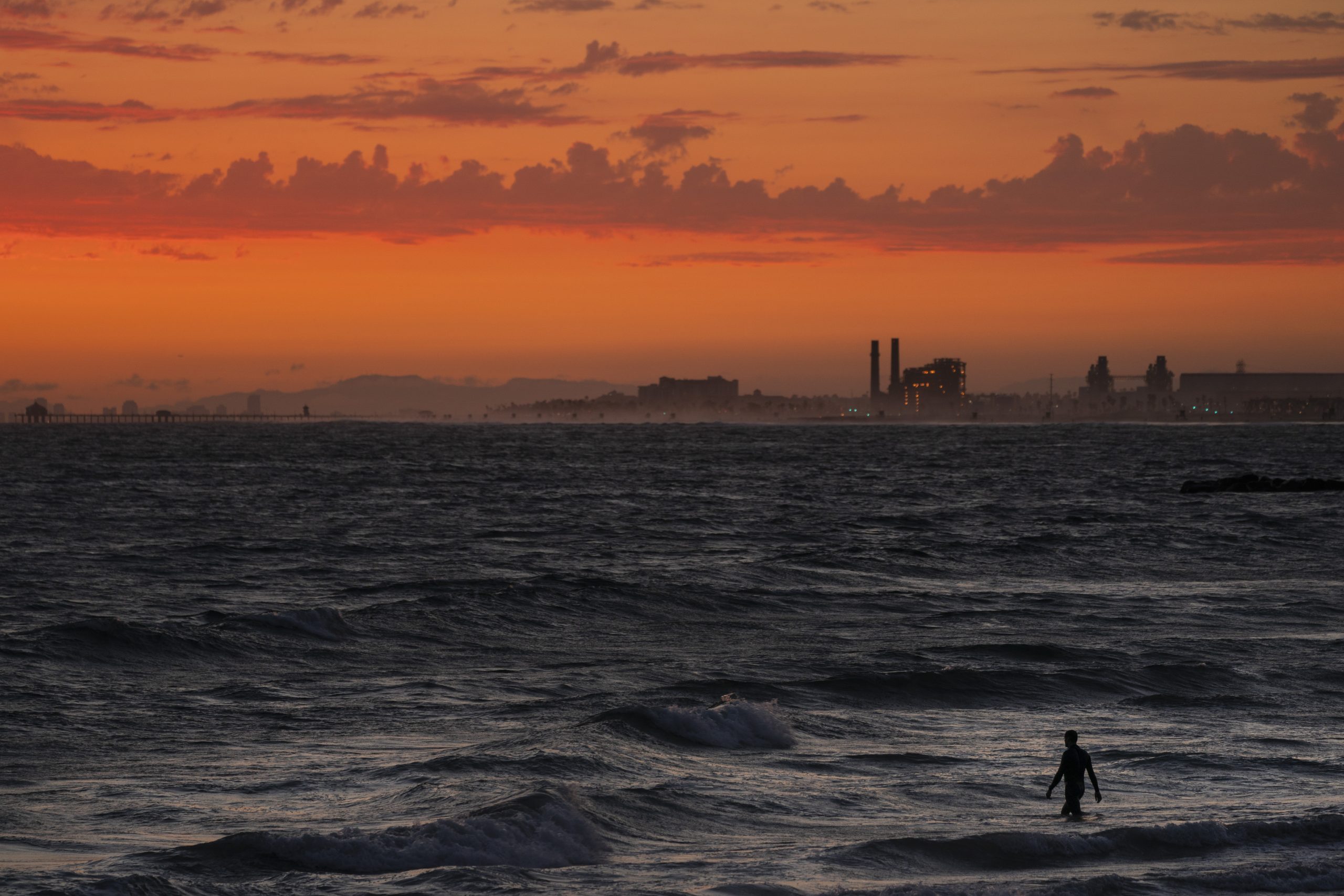 FILE - A man wades into the ocean at sunset on June 22, 2021, in Newport Beach, Calif. The National...