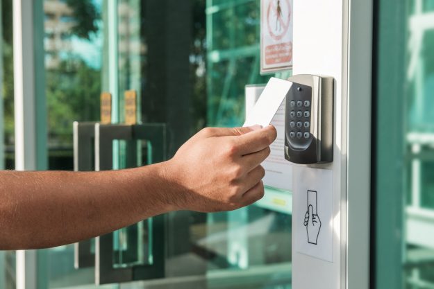 Hand using security key card scanning to open the door / security solutions