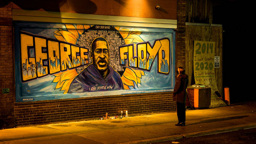 A woman looks at a mural on the wall of Cup Foods during a vigil for George Floyd on May 25, 2022 i...