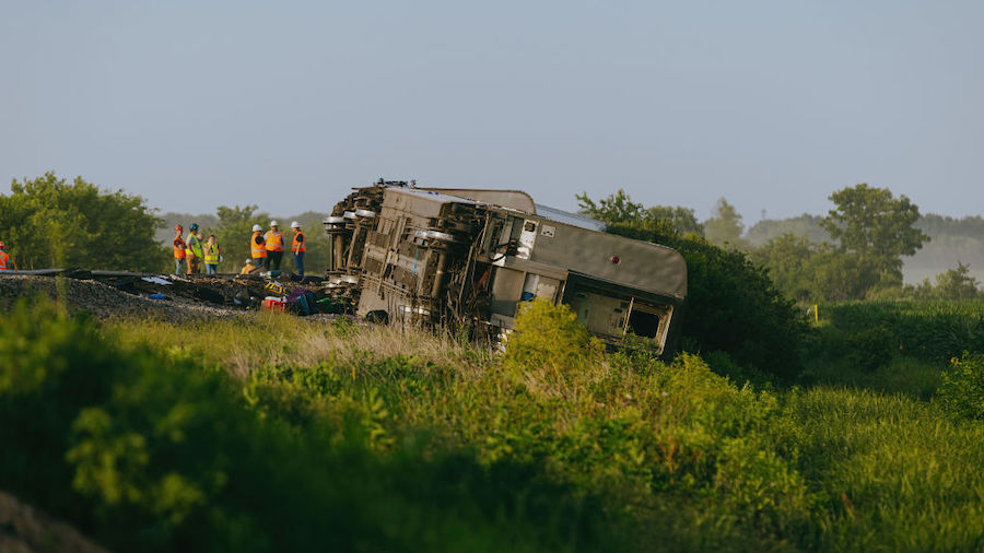 Railroad workers work the scene where an Amtrak train derailed on June 27, 2022 in Mendon, Missouri...